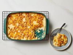 a casserole dish on a cooling rack next to a plate with a spoon