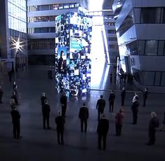 a group of people standing around in the middle of a building with lights on it