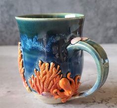 a ceramic mug with an octopus and seaweed design on the inside is sitting on a table