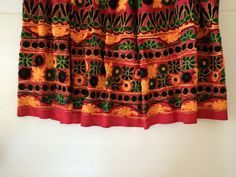 Stunning Ethnic Skirt in Bright, Burnt Red with Ornate Embroidered Decoration.Bright color w deep green, black, fire orange embroidered of patterns and flowers.The colors are outlined w gold metallic stitching.  Absolutely beautiful!!I think this wonderful piece may be Mexican, although not marked.Cotton w elastic waist.There may be some pulling of the hand done embroidery and loose or missing sequins, typical of a complicated ethnic textile such as this.Closest to a M / L.Measurements when lyin Traditional Skirt With Resham Embroidery For Navratri, Festive Floral Embroidered Skirt, Traditional Long Skirt With Resham Embroidery, Traditional Skirt With Resham Embroidery For Festivals, Traditional Skirt With Intricate Embroidery For Festive Occasions, Bollywood Style Embroidered Long Skirt, Bollywood Style Long Embroidered Skirt, Folk Style Multicolor Embroidered Skirt, Folk Style Embroidered Multicolor Skirt