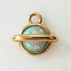 A kaleidoscopic, dimensional planet charm guaranteed to spark joy for all you stargazers. Wear this piece of the galaxy on it's own or on a jumble alongside your favorite charms on a necklace, bracelet, or strung upon hoops. Charm measures 9mm x 7mm. Simulated opal. Comes with a removable oval jump ring. Our materials make for an amazing, high quality, seamless, jewelry piece with longevity. Our rings are plated with 18k gold, 18k rose gold, or sterling silver and finished with a protective coat Saturn Charm, Mood Ring, Spark Joy, I Love Jewelry, Photo Template, Charm Gift, The Galaxy, Necklace Bracelet, 18k Rose Gold