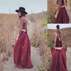 a woman in a long red skirt and hat walking through tall grass with her hands on her hips