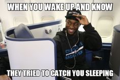 a man sitting on an airplane with headphones in his ears and the caption says, when you wake up and know they tried to catch you sleeping