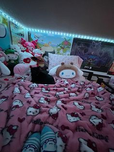 there are many stuffed animals on the bed in this room with pink sheets and pillows