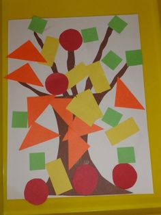 an art project made with construction paper and colored stickers on a yellow frame, depicting a tree