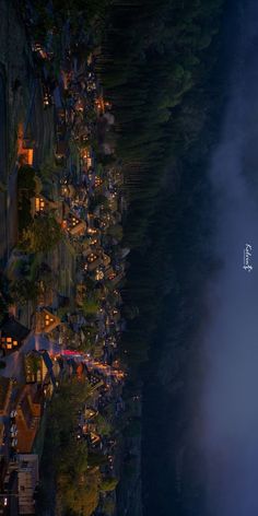 an aerial view of a town at night, with fog in the air and trees