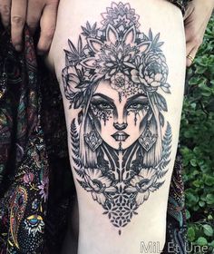 a woman's face with flowers and leaves on her thigh