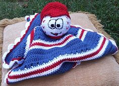 a crocheted blanket with a clown face on it sitting on top of a pillow