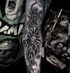 a man's arm with an octopus and skull tattoo on the left side of his arm