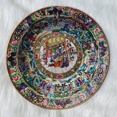 an elaborately decorated plate on a white furnishing with lots of colorful designs