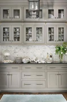 a kitchen with gray cabinets and white counter tops