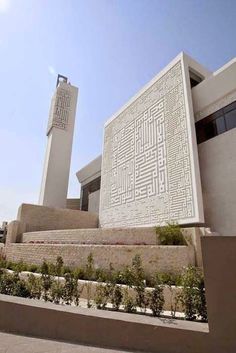 the building has an intricate design on it's side and is surrounded by plants