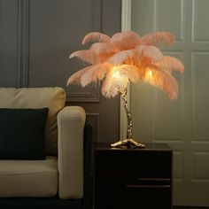 a lamp that is on top of a table next to a couch with pillows and a pillow