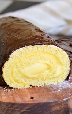 a piece of chocolate covered pastry sitting on top of a wooden cutting board