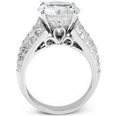 an engagement ring with a heart shaped diamond on the side and two rows of diamonds around it