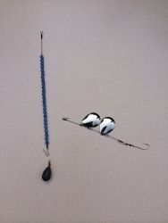 two birds sitting on top of a blue beaded necklace next to a hook with beads