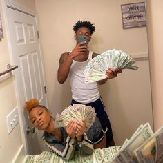 a man taking a selfie in front of a mirror with money on the bed