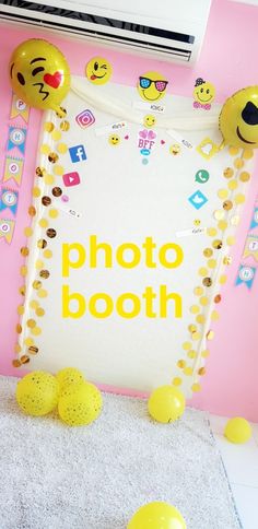 a photo booth with balloons and emoticions on the floor in front of it