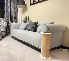 a living room filled with furniture and a cat scratching post in front of the couch