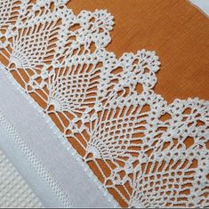 an orange and white piece of cloth with lace on it