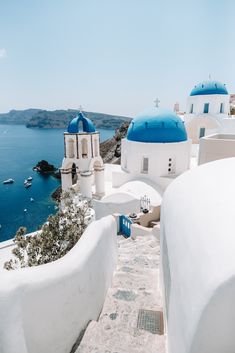 white buildings with blue domes overlook the ocean