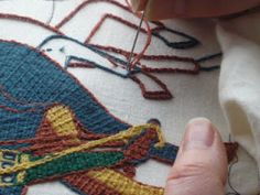 someone is working on an embroidery project with scissors