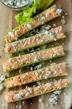 sliced celery and lettuce on a cutting board next to a bowl of feta cheese