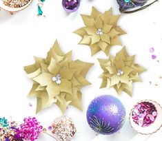 several different types of ornaments on a white surface with purple and gold decorations around them