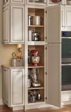 an open cabinet in the middle of a kitchen