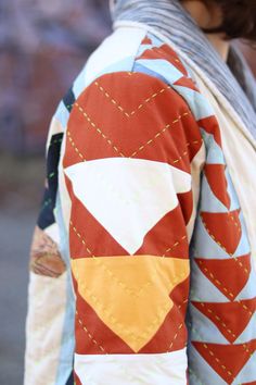 a close up of a person wearing a jacket with an orange and white design on it