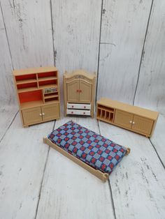 a dollhouse bedroom with furniture and accessories including a bed, dresser, bookcase