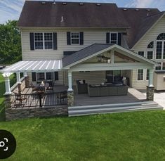 a large house with a covered patio in the front yard and an outdoor living area