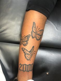 a woman's arm with three butterflies on it and the word tattoos written in black ink