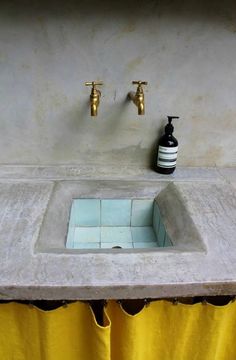 a bathroom sink with two faucets and a soap dispenser