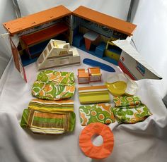 an assortment of dollhouse furniture and accessories laid out on a white sheeted surface