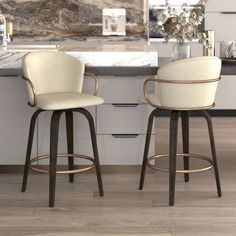 two white bar stools sitting in front of a marble counter top and an island