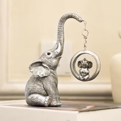 an elephant figurine sitting on top of a table next to a key chain