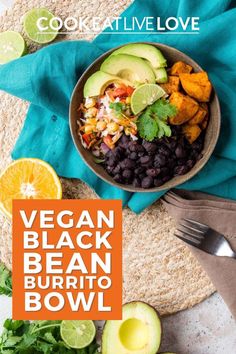 a bowl filled with black beans, avocado and limes next to an orange slice