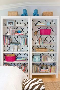 a white bookcase with black and white wallpaper