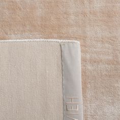 the back side of a beige and white rug with two different color swatches on it