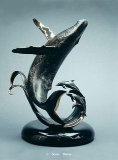 a statue of a dolphin with its mouth open and it's tail curled up