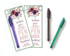 two pen pens sitting next to each other on top of a white table with flowers