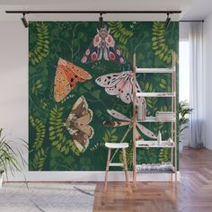 butterflies and ferns on green wall mural in living room with wooden ladder, potted plant and window