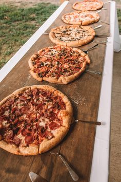 several pizzas are lined up on a long table