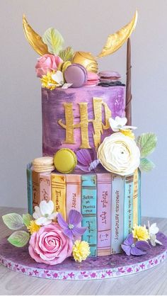 a multi - tiered cake decorated with books and flowers