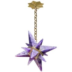 a purple origami star hanging from a gold plated metal chain on an isolated white background