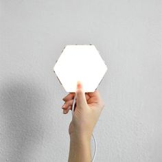 a person holding up a white light in their hand