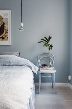 a bedroom with blue walls and white furniture