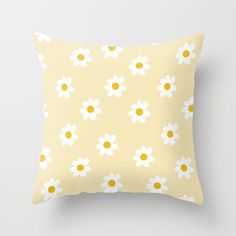 a yellow pillow with white daisies on it