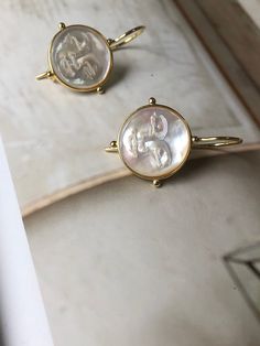 This beautiful statement earring is designed and created to match back to our moon necklace which can be purchased here: https://www.etsy.com/hk-en/listing/1042018212/moon-face-necklace-14mm-mother-of-pearl?click_key=3850f9f0d2df9239bd75e3bcff004c2a10c0446e%3A1042018212&click_sum=b8f1dfbd&ref=shop_home_active_12&pro=1&frs=1 Featuring a luminous mother of pearl carved moon face, set in a minimal design allowing the moon to shine brightly on its own. This is a beautiful high quality product you wi Round Brass Pearl Earrings, Round Mother Of Pearl Earrings, Elegant Moon Shaped Hoop Earrings As Gift, Elegant Moon-shaped Hoop Earrings For Gifts, Elegant Moon Shaped Hoop Earrings For Gift, Handmade Mother Of Pearl Round Pearl Earrings, Handmade Round Mother Of Pearl Earrings, Handmade Mother Of Pearl Earrings, Elegant Hoop Earrings With Moon Charm